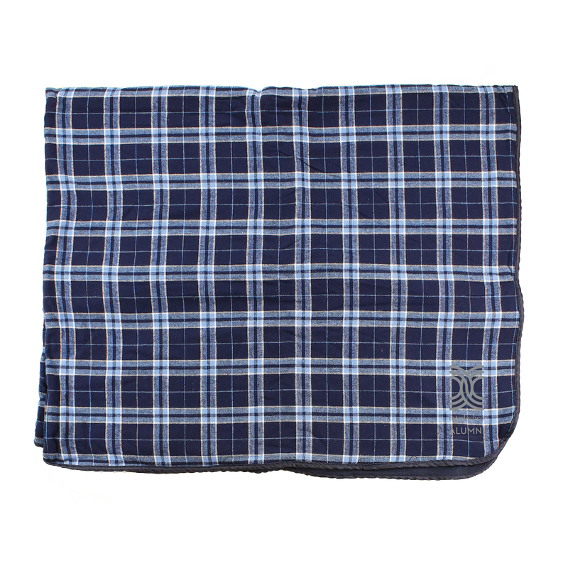 A navy and blue plaid flannel blanket with a visible logo.