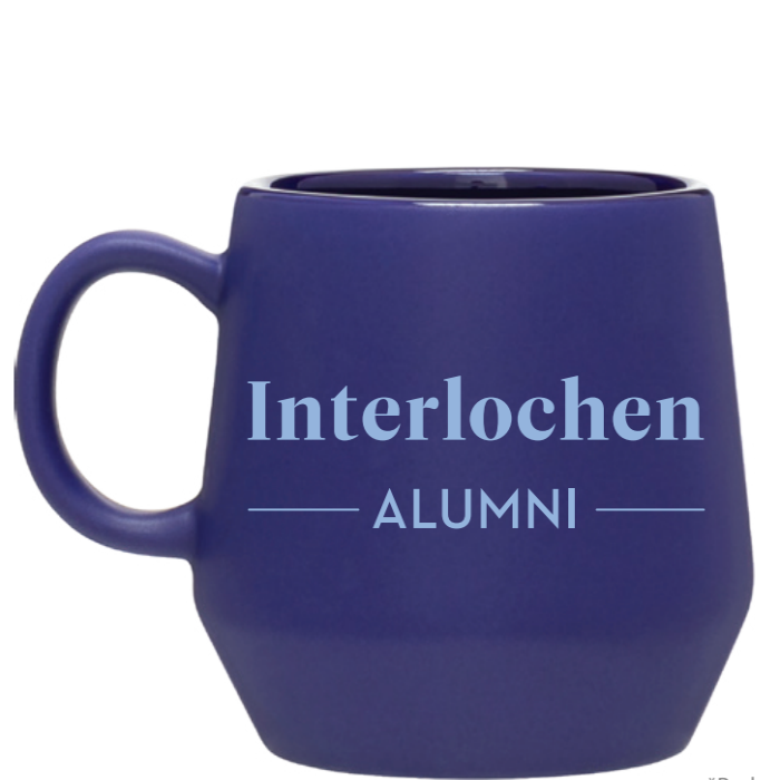 A cobalt blue ceramic mug with 'Interlochen Alumni' printed on the side.
