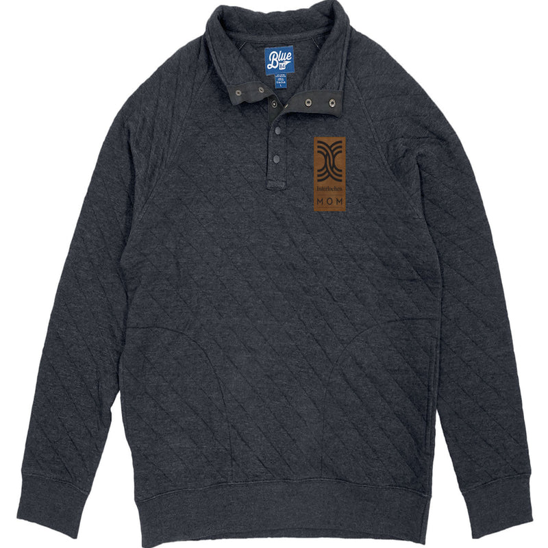 A navy quilted 1/4 snap up pullover with a visible brand tag on the upper left side.